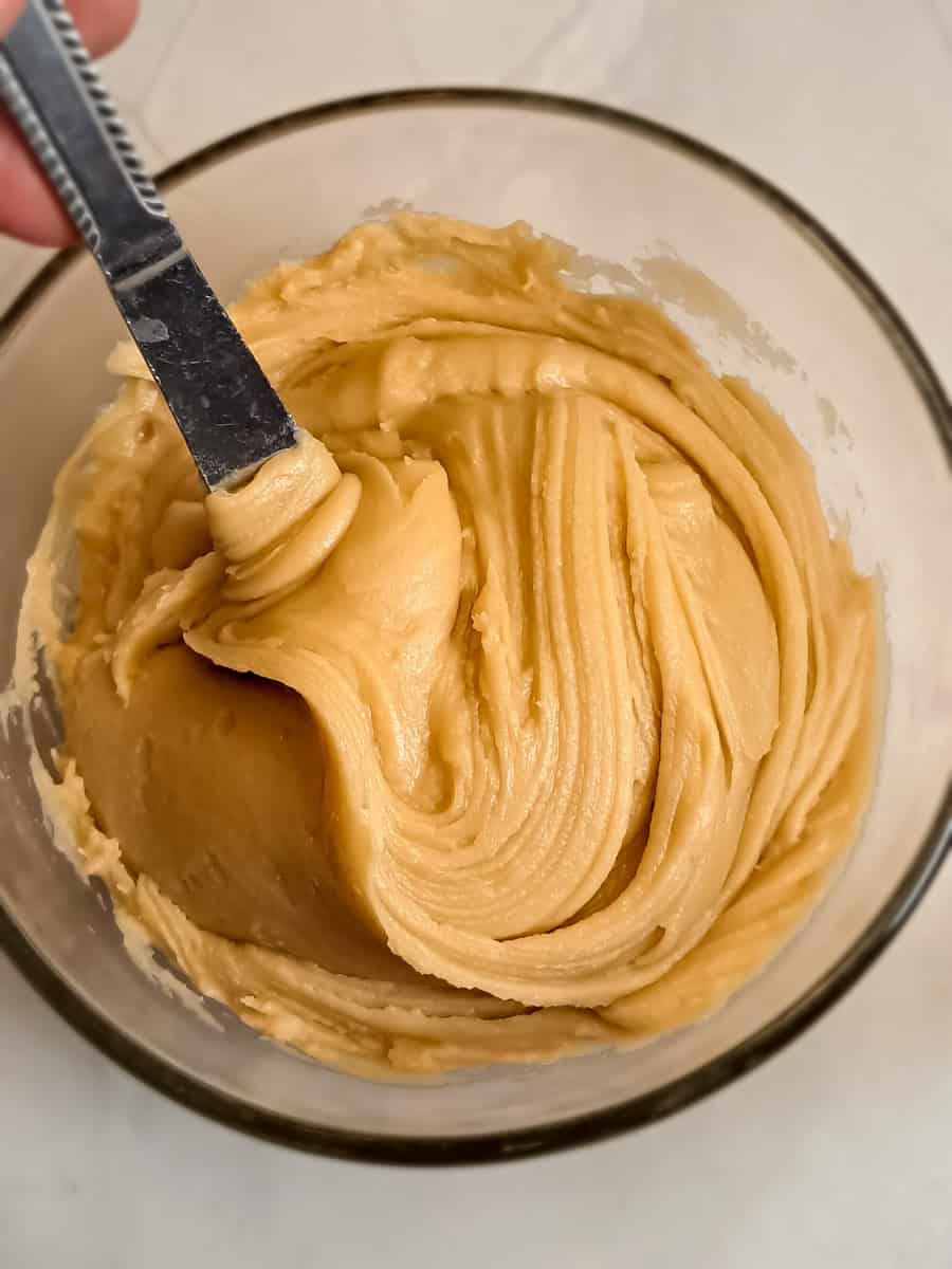 a bowl of caramel frosting for cinnamon rolls.