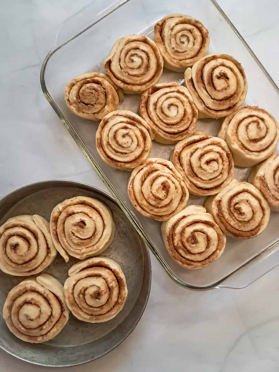 cinnamon rolls in a pan ready to rise again.