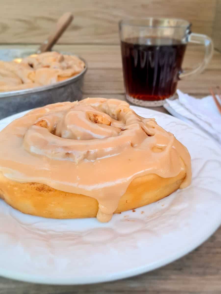 cinnamon roll with caramel icing poured on top.