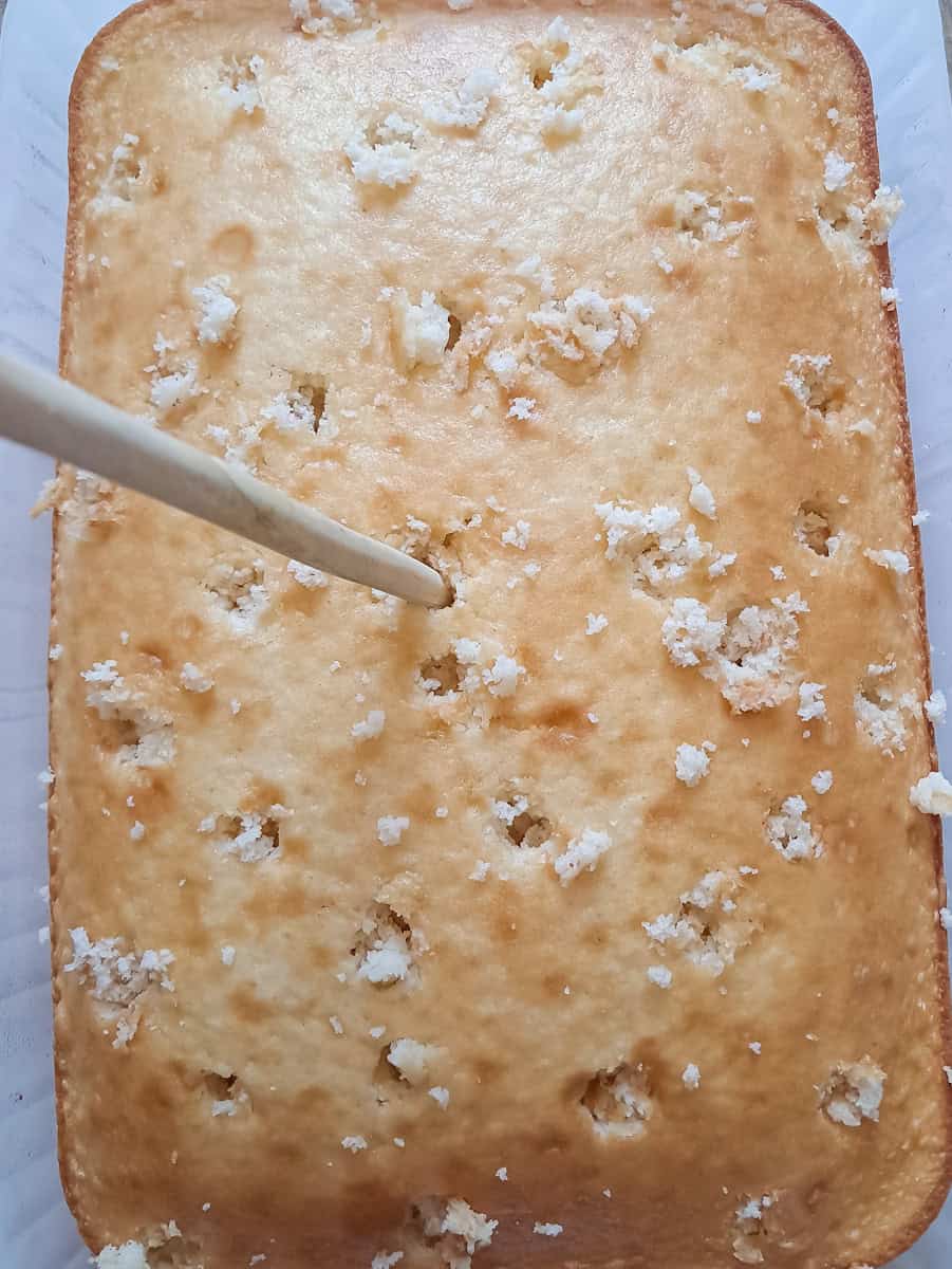 holes poked into a pan of white cake.