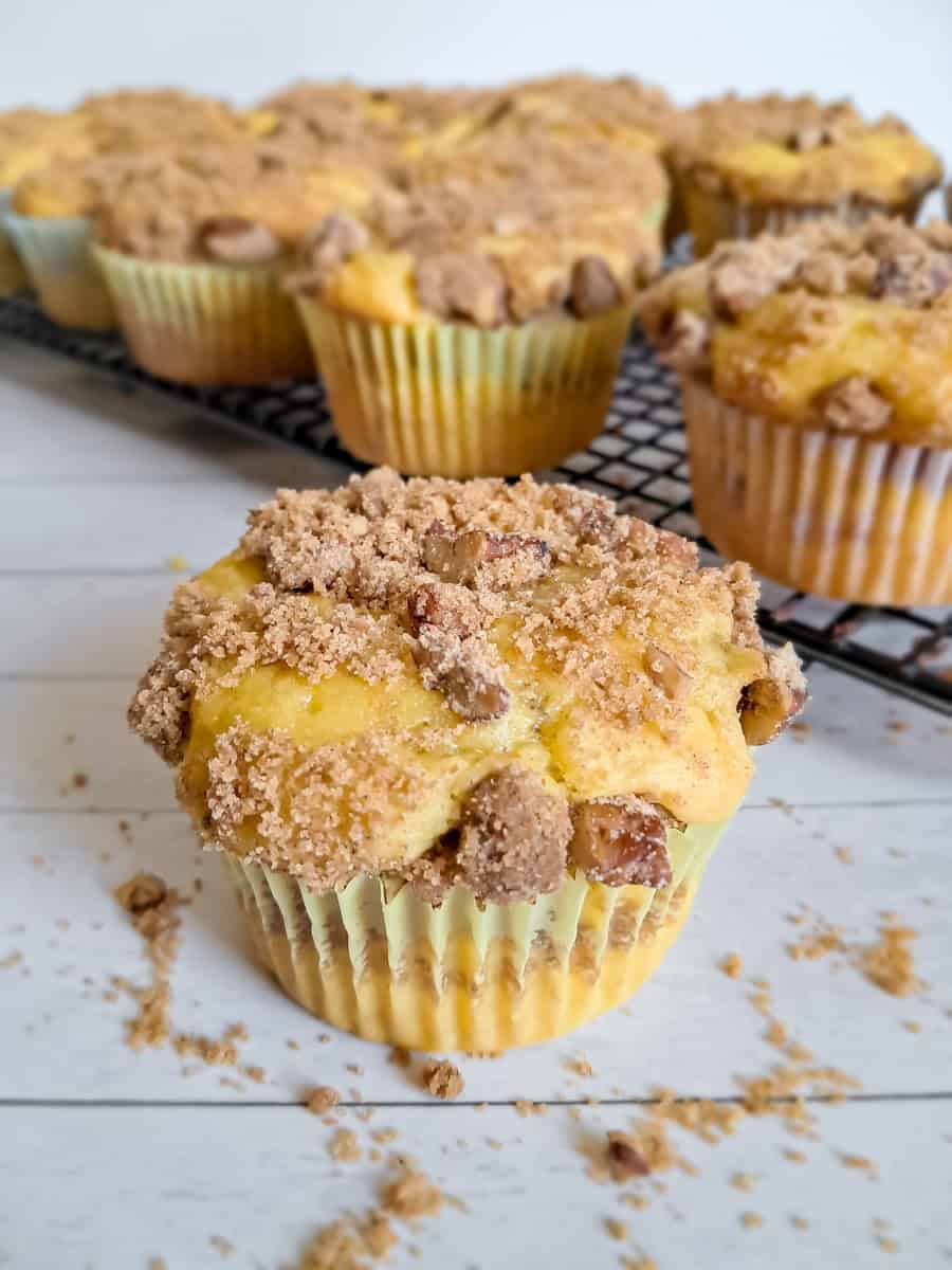 Close-up of an Amish coffee cake muffin and more on a rack in the background.