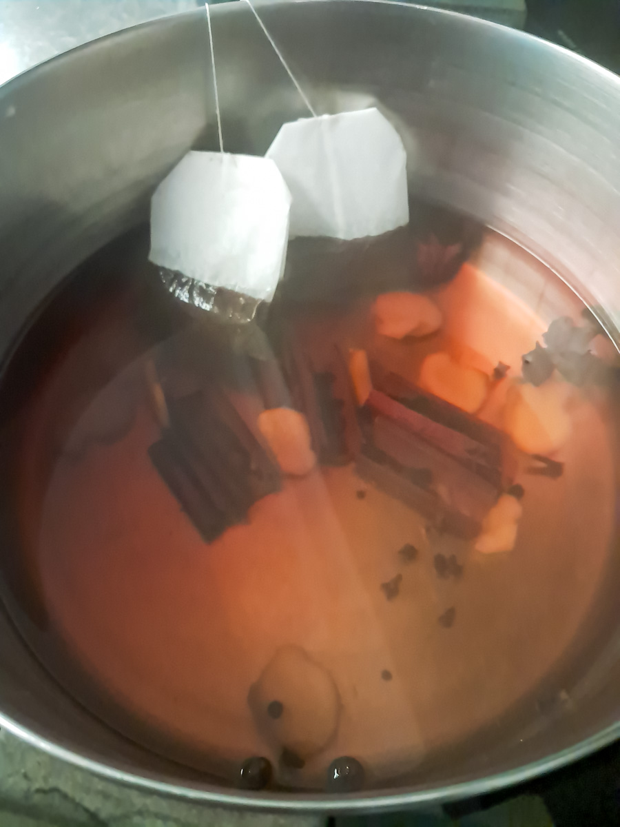 brewing chai concentrate in a large pot.