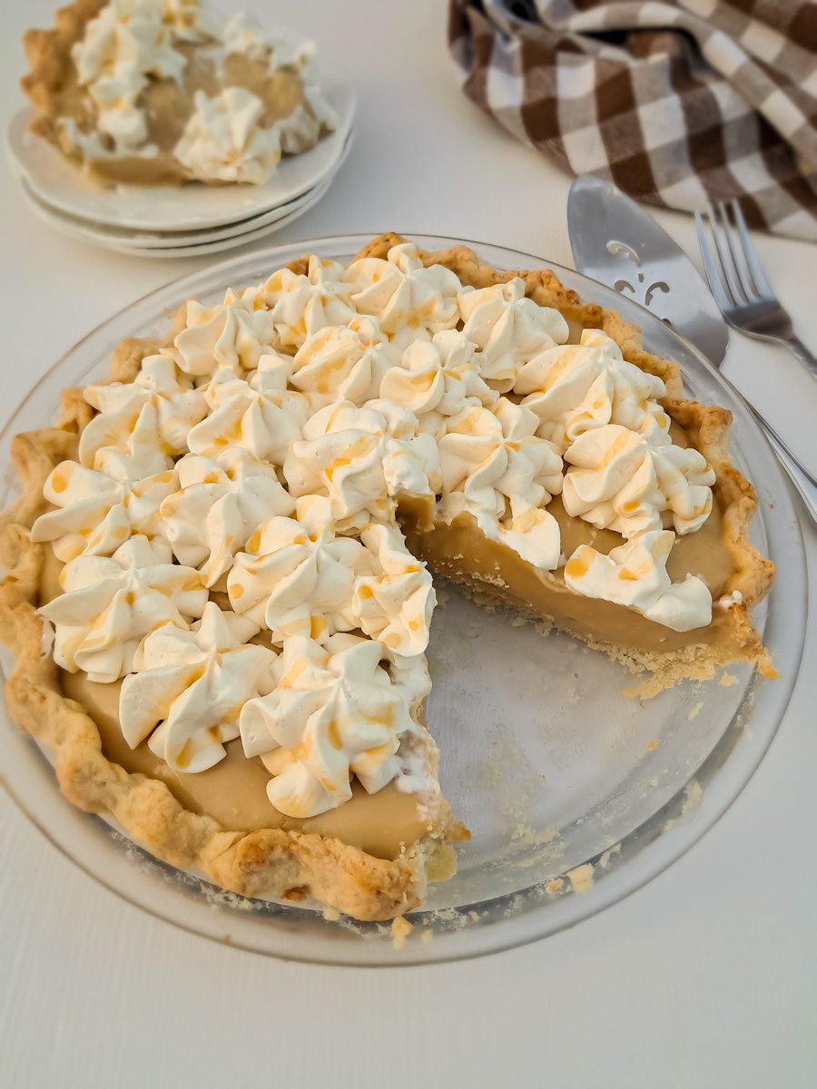 whole 9" Amish butterscotch pie with a slice removed.