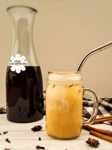 a glass with chai tea and the bottle of chai concentrate in the background.