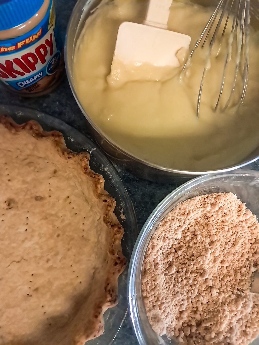 pre-baked pie crust, pudding in a saucepan, and peanut butter crumbles in a small bowl.
