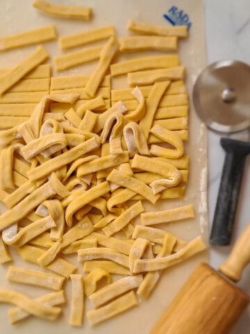 a cutting board full of homemade Amish egg noodles.