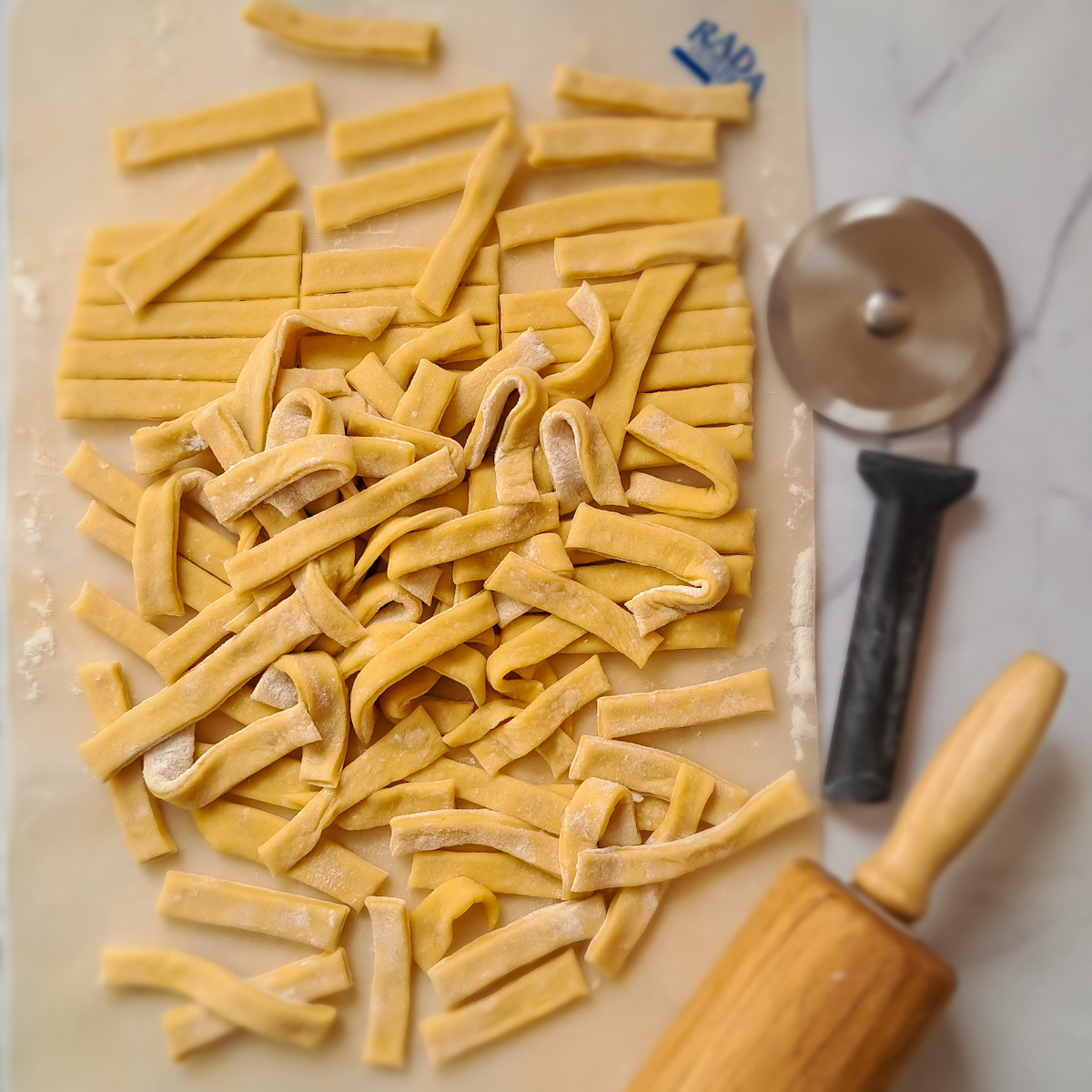 a cutting board full of homemade Amish egg noodles.