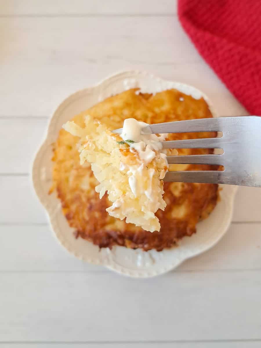 featuring a bite of an Amish potato pancake with sour cream on top.