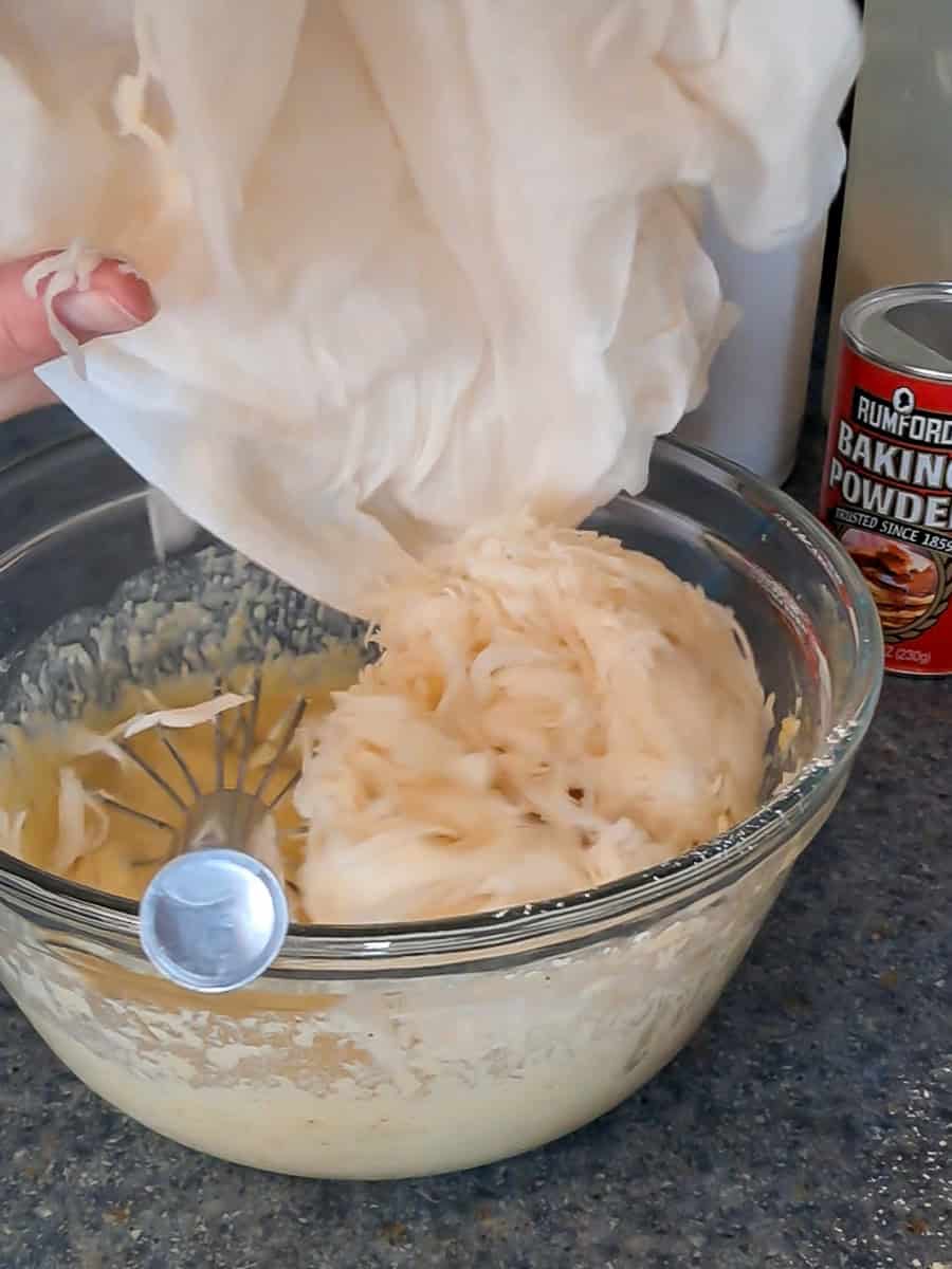 adding grated potatoes to the pancake batter.