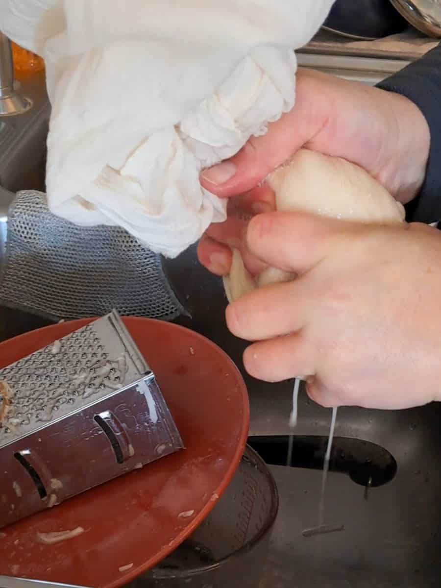 squeezing extra liquid out of shredded potatoes in a cheesecloth.