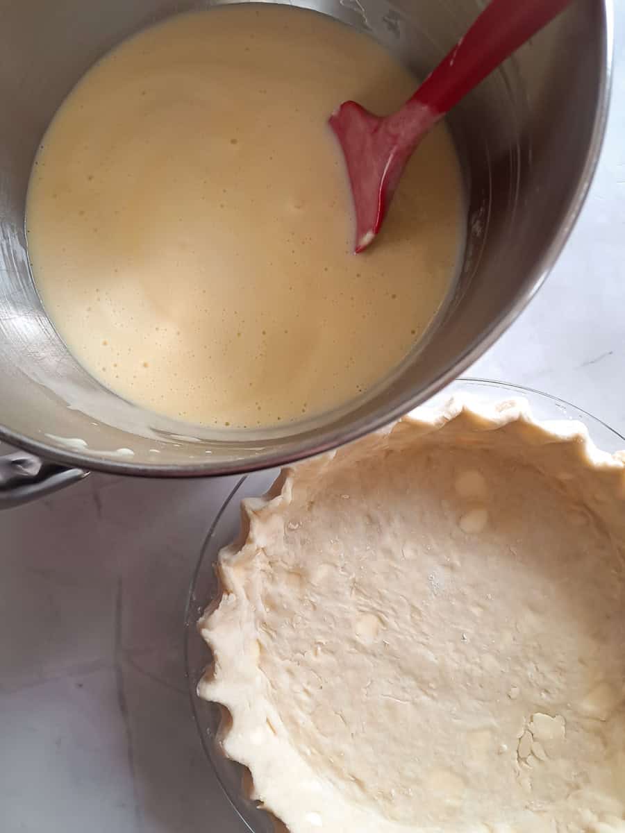 pie filling in a large bowl and a 9" crust ready to be filled.