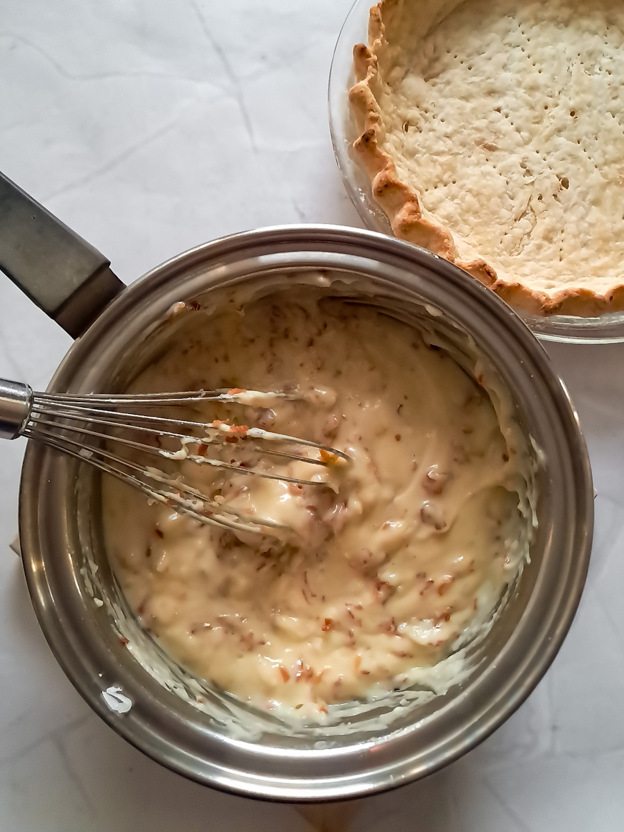coconut cream custard filling in saucepan ready to fill the empty pie crust.