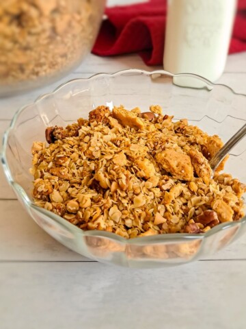 a bowl of homemade Amish butterscotch granola cereal with a jar of milk and remaining granola in background.