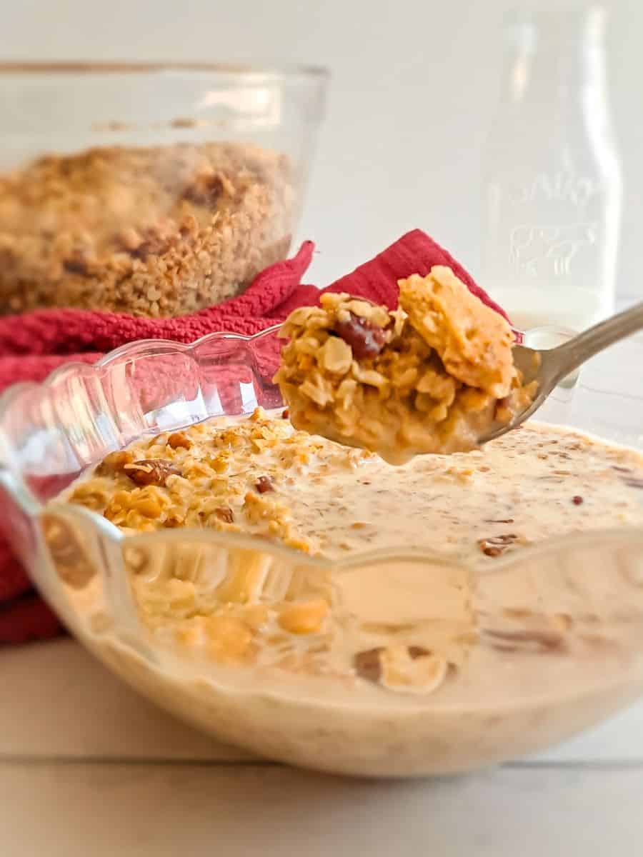 butterscotch granola cereal in a bowl with milk, featuring a spoonful of granola ready to eat.