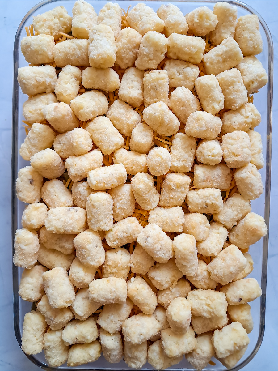 frozen tater tots are spread over the top of everything that's layered into the dish just before baking.