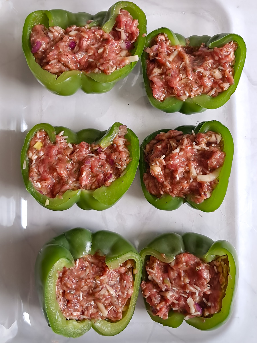 stuffed peppers in a baking dish ready for the oven.