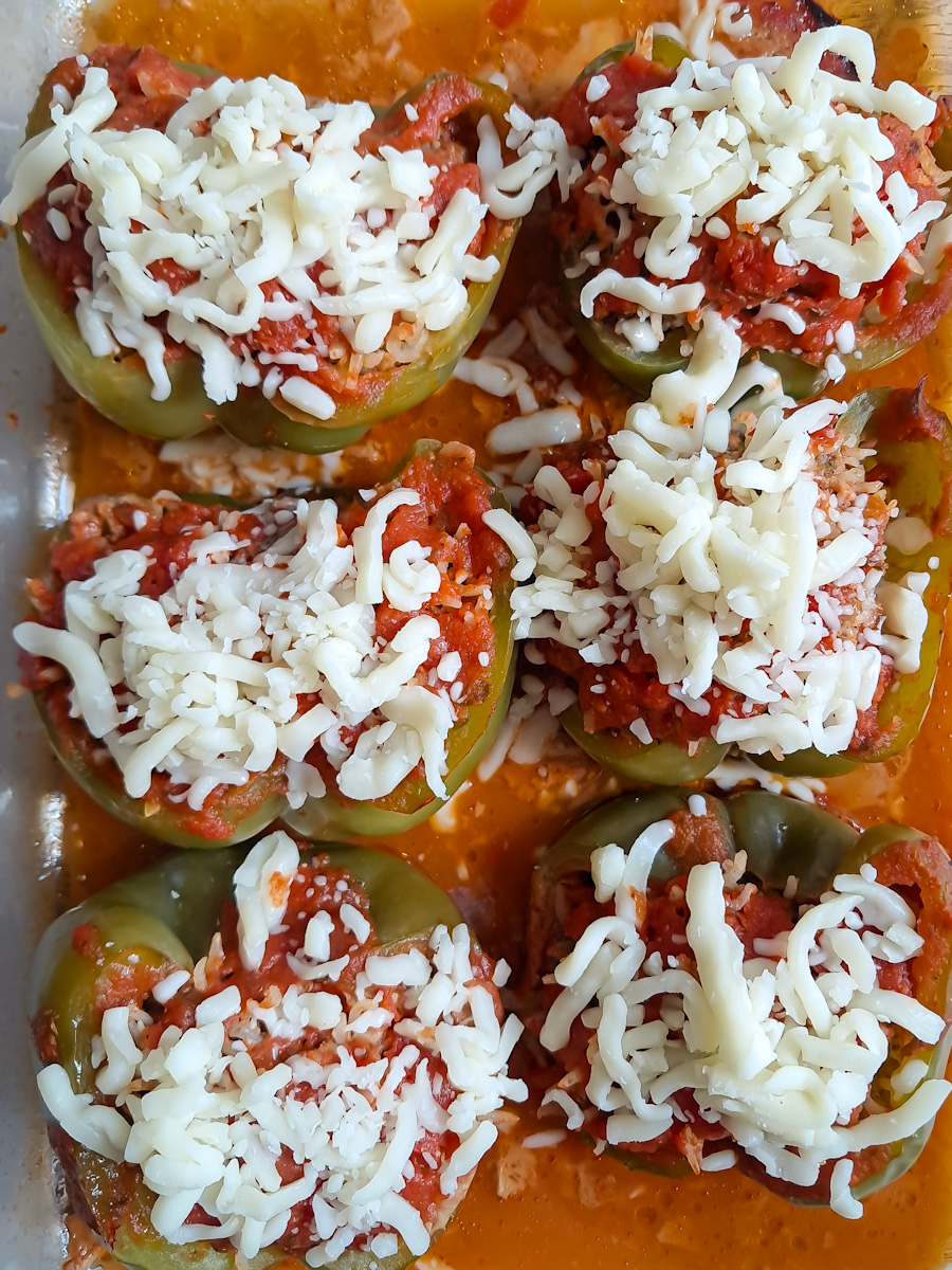 baked green peppers stuffed with a ground beef and rice mixture spread with shredded cheese. now we need to bake them another 10 minutes.