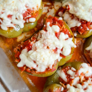 close up of ground beef and rice stuffed green pepper topped with sauce and cheese.