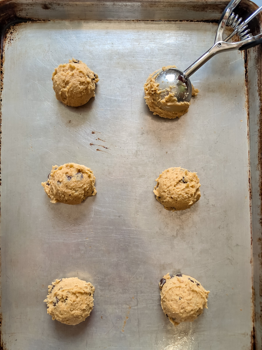 scooping the cookie dough onto a large baking sheet.