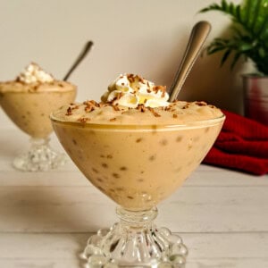 two glass goblet dishes full of Amish butterscotch tapioca pudding with whipped cream on top.
