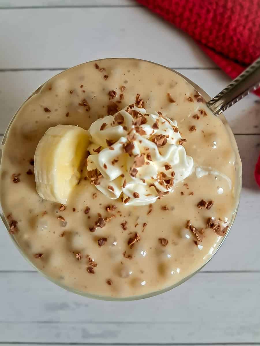 butterscotch tapioca with whipped cream, banana slice, and chocolate shavings.