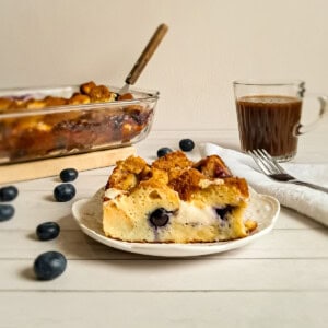 featuring a plate of baked french toast with blueberries and cream cheese.