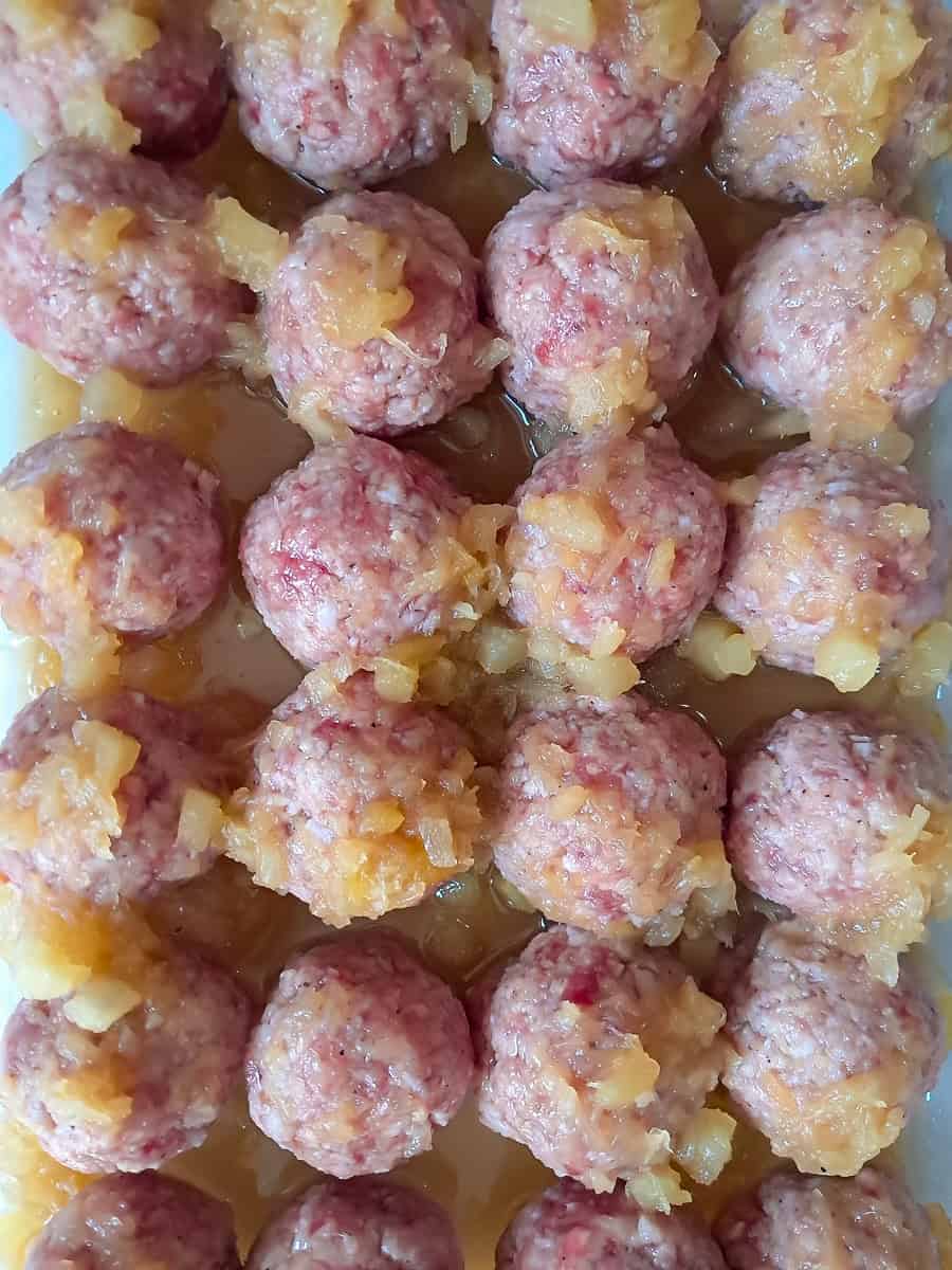 a pan full of pineapple glazed ham balls ready to bake.
