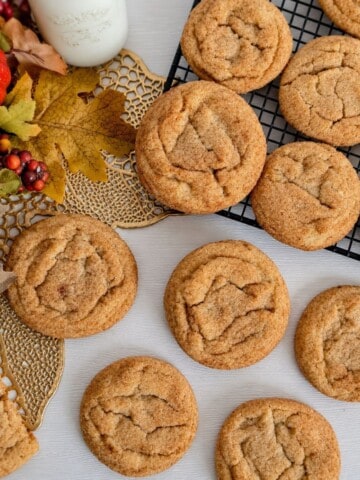 pumpkin pie spice cookies on a white background with a jar of milk and a bit of fall decor.